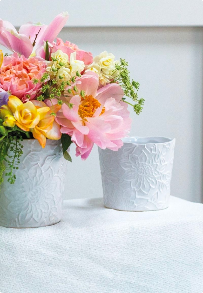 white vase with embossed textured flowers on it